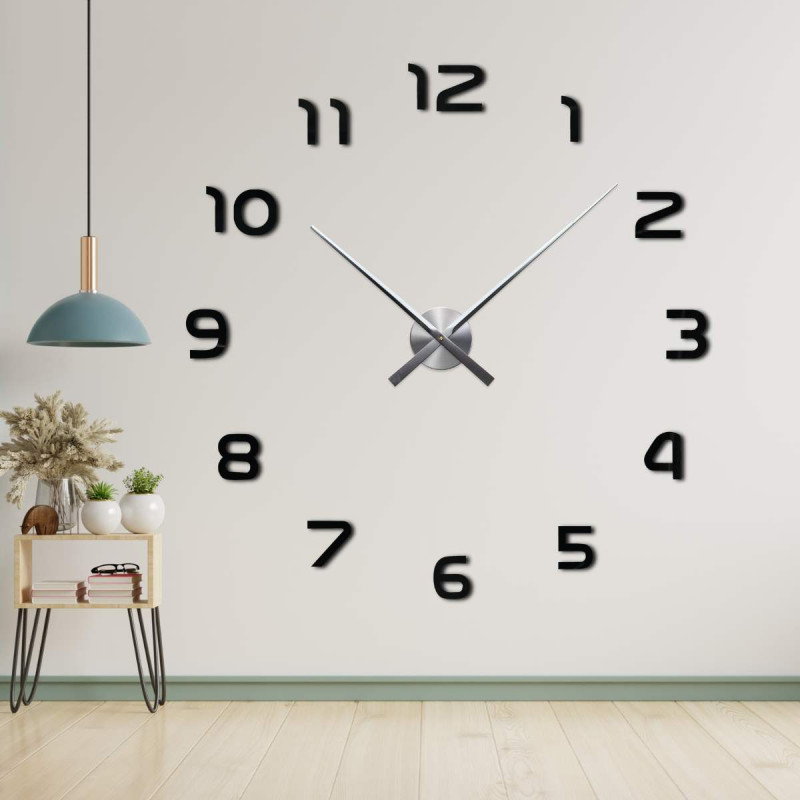 Hodiny bez rámu s centrálním mechanismem a dlouhými ručičkami.