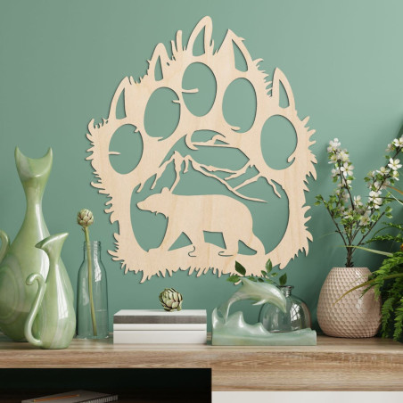 Kontrastní silueta medvědí stopy, uvnitř které je vidět horský masiv a postavu medvěda kráčejícího vpřed.