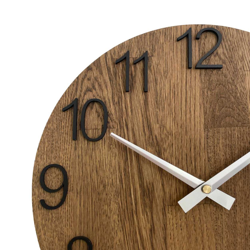 Kruhové hodiny s dekorativním výřezem ve středové části a jemnou kresbou dřeva.